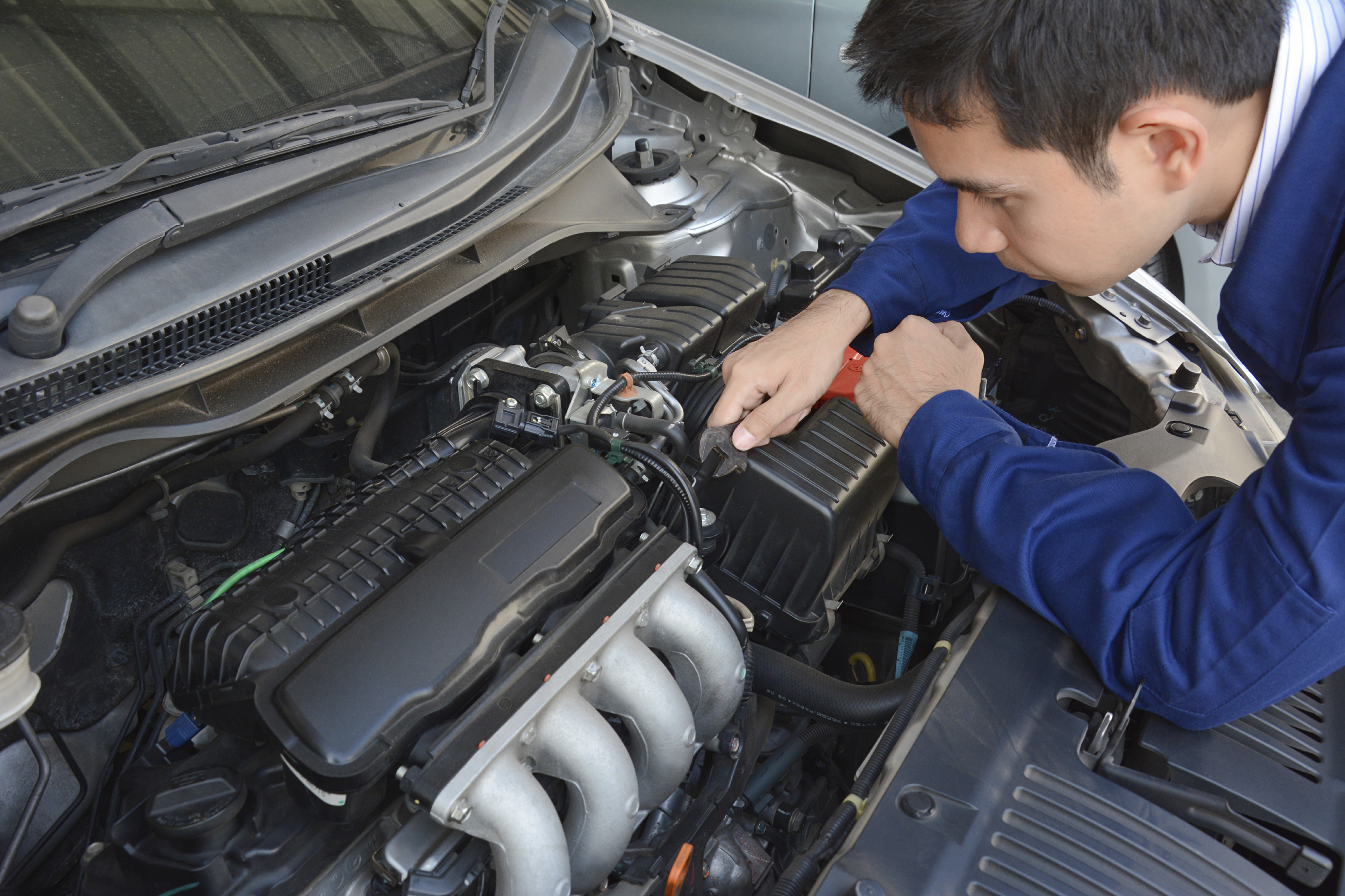 Auto mechanic (or technician) fixing car engine